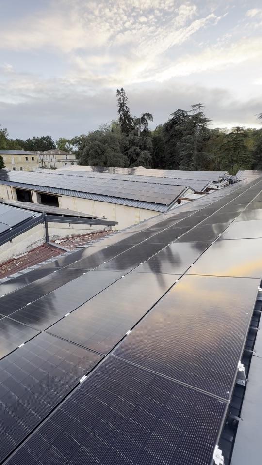 Vue filmée d'une grande toiture photovoltaïque au coucher du soleil